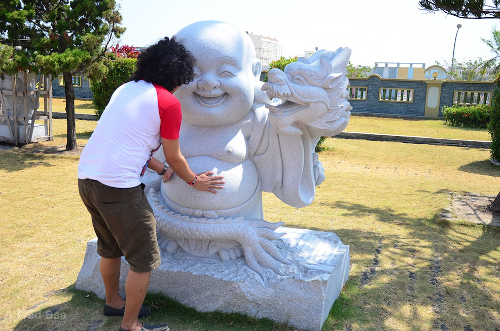 Rubbing buddha's tummy for luck